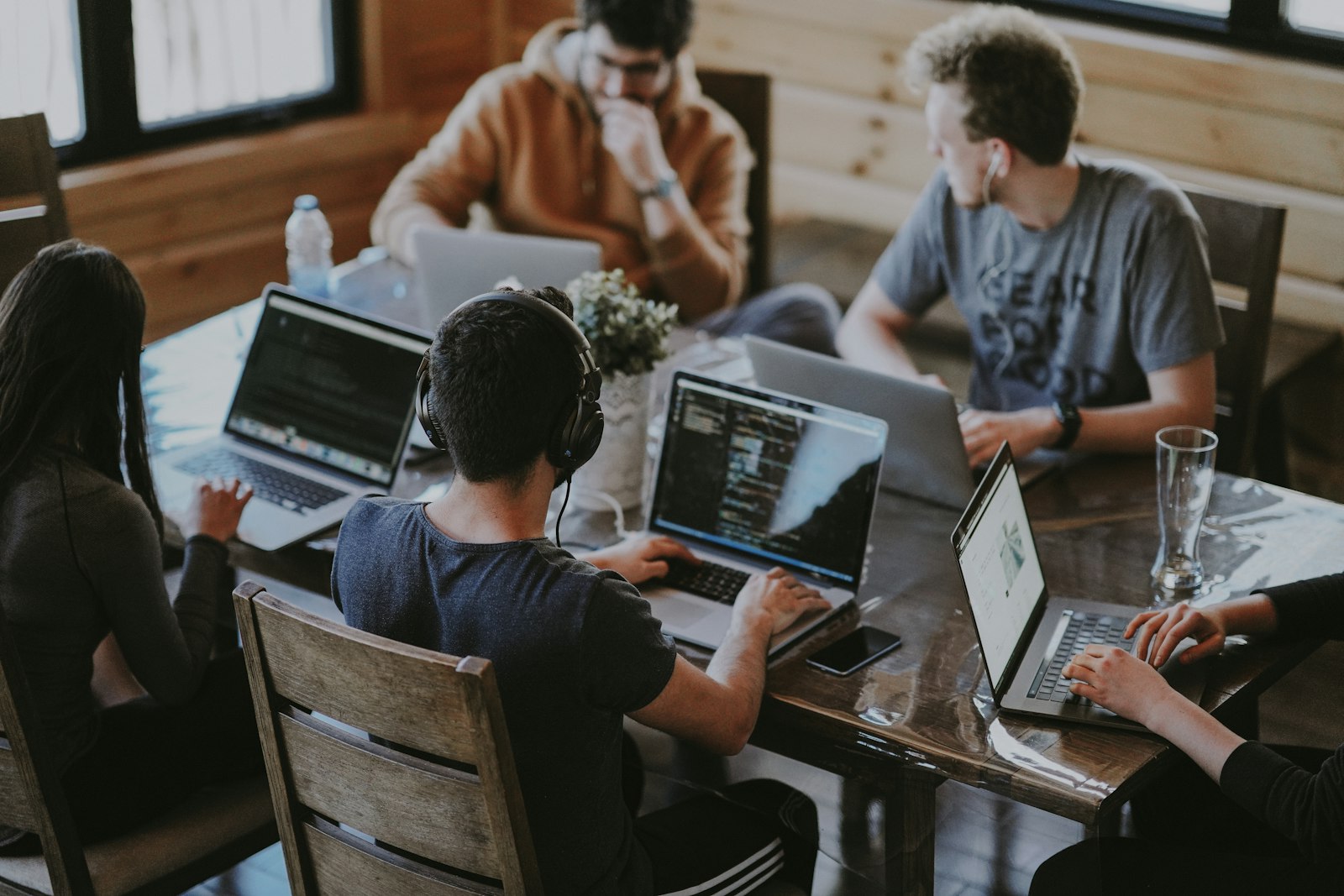 Professionals collaborating around a table with laptops; illustrative stock photograph, not a depiction of MILD employees or clients.